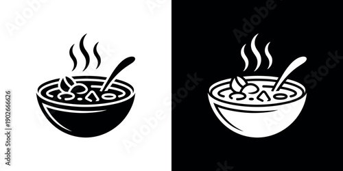 Black and white bowl of soup with steam and spoon