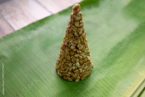 Seed cone made of natural ingredients on green leaf