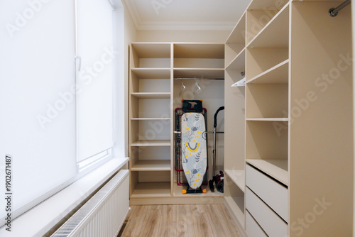 Tableau sur toile Organized wardrobe featuring ironing station and natural light