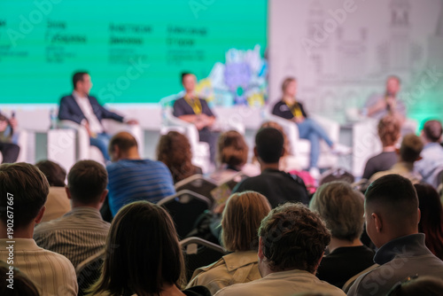 Wallpaper Mural Panel discussion at conference with speakers on stage and attentive audience. Bright backdrop creates energetic mood. Torontodigital.ca