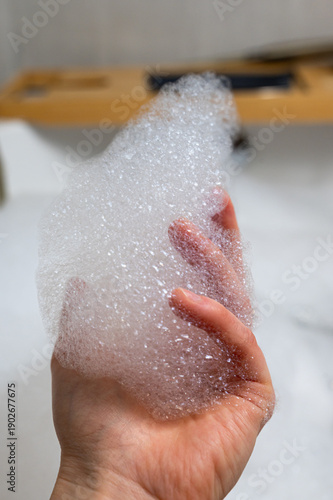 Bild auf Leinwand Detailed view of fingertips cradling airy bubbles in calming bath setting