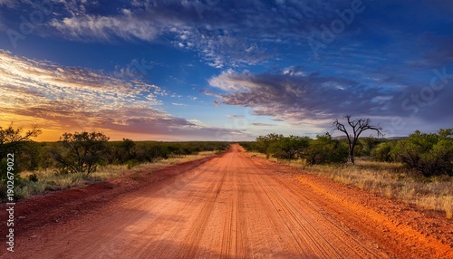 A Long Dirt Road Stretching Through The Texas Wilderness With A Vibrant Sky Above