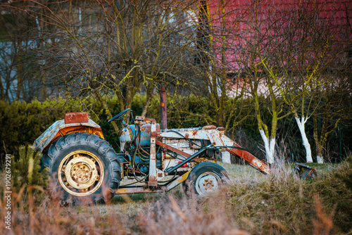 Old Vintage Tractor Parked on Rural Farmyard Near Barn
