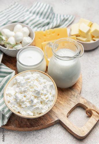 Assortment of fresh dairy products on wooden cutting board