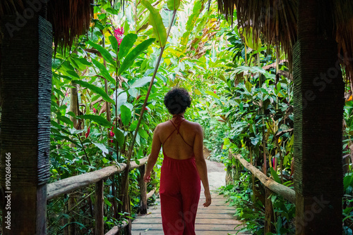 Chica relajándose en cabaña en la selva con piña colada en Samaná