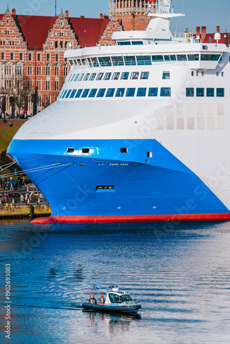 Large Passenger Ferry Ship in Harbor with Patrol Boat
