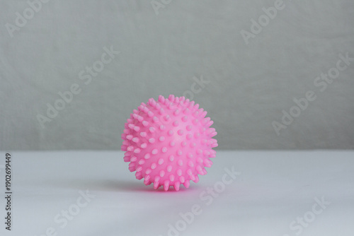 фотографія Pink spiky massage ball for physical therapy and myofascial release isolated on a neutral grey background