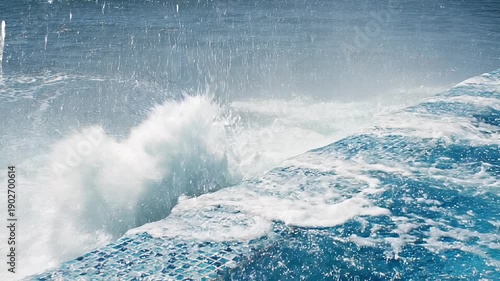Ocean wave crashing into swimming pool