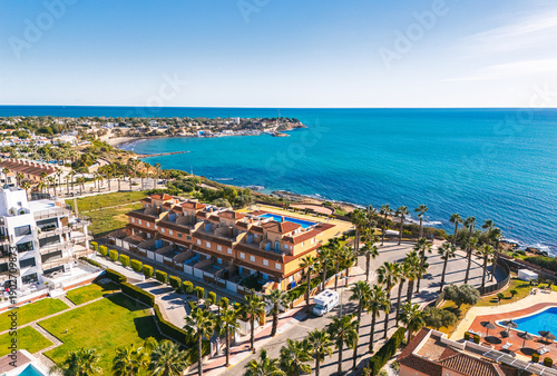 Aerial view Cabo Roig coastal town on southern Costa Blanca, Mediterranean Sea and seafront residential buildings during sunny day. Province of Alicante. Spain