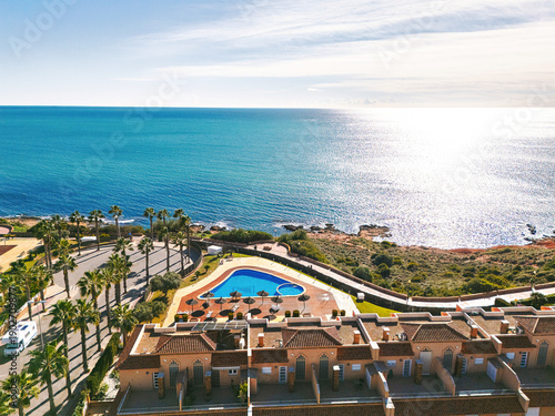 Aerial view Cabo Roig coastal town on southern Costa Blanca, Mediterranean Sea and seafront residential buildings during sunny day. Province of Alicante. Spain