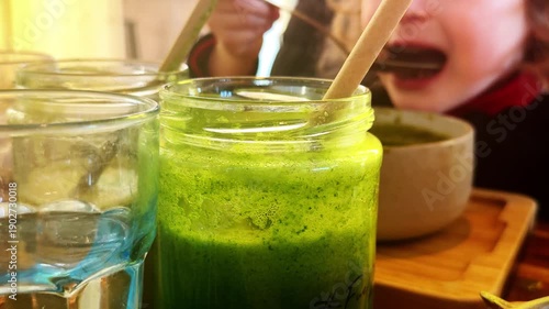 Child eating green vegetable soup