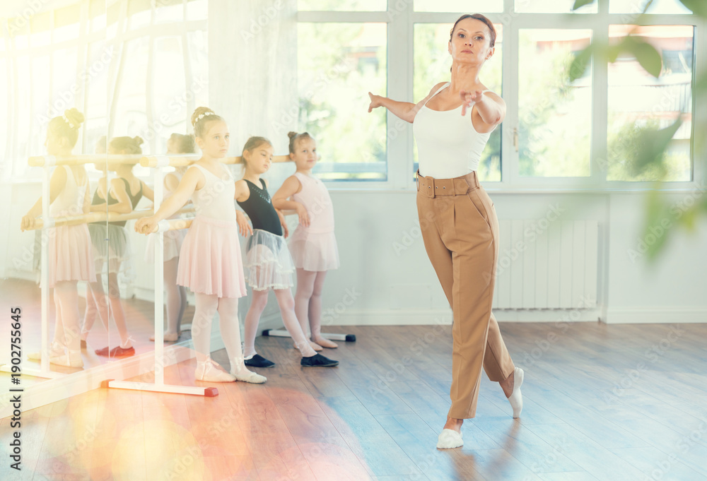 Fototapeta premium Children visitors to choreographic classes, observe professional rendering of dance elements, performances middle-aged woman couch. Aesthetic hobby for fans of active lifestyle