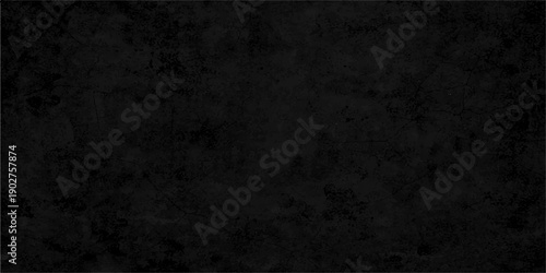 A dark and textured grunge wall background featuring a vintage gray concrete surface with an aged stone pattern and rough black paper backdrop for a dirty industrial design