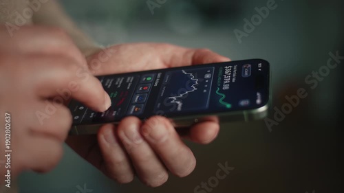 Wallpaper Mural Close-up male hand holding smartphone with financial investment app showing portfolio growth and rising chart. Daylight indoor low light scene with stock market data, fintech wealth management at home Torontodigital.ca