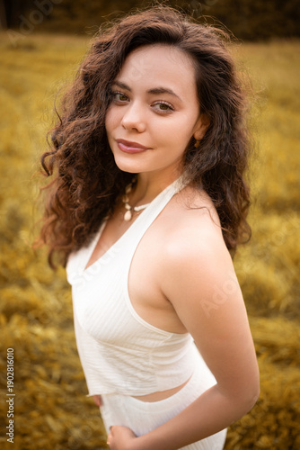 Beautiful Young Woman with Curly Hair in Summer Field at Golden Hour