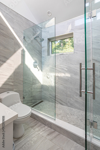 Modern bathroom with glass walk in shower and gray marble tile