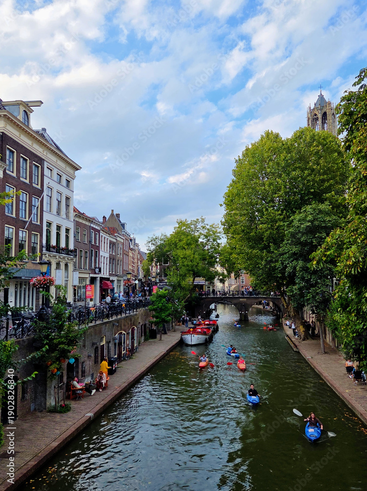 Fototapeta premium Colorful Kayaks and Tour Boats Navigating the Historic Oudegracht Canal in Utrecht