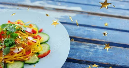As golden stars start drifting, white plate with salad moving into center, revealing dish for menu