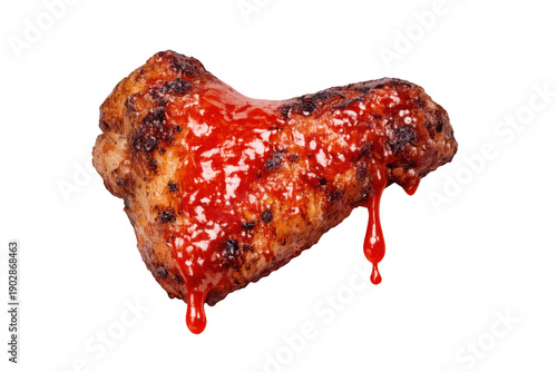 Grilled chicken wing covered in vibrant red spicy barbecue sauce, with sauce drops. Roasted meat on transparent background