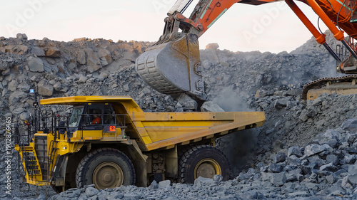 Fotografi Rock extraction and loading process using heavy mining machinery