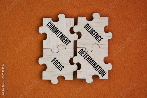Tableau sur toile Wooden puzzle with the words commitment, diligence and focus, determination