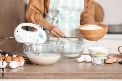 Woman sifting flour into bo...