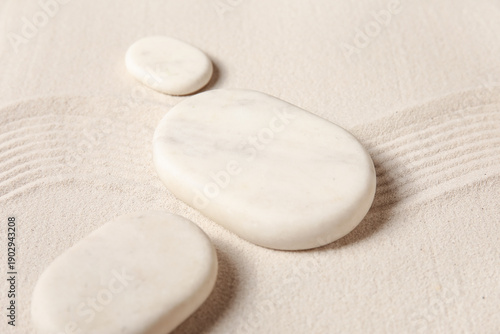 Canvas Print Composition with spa stones and lines on light sand as background, closeup