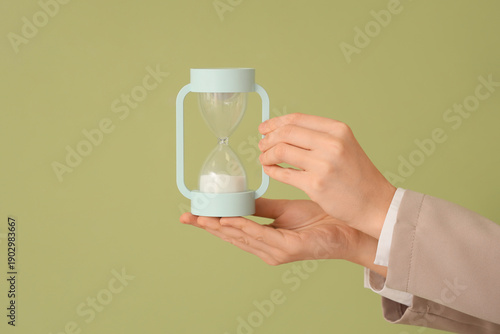 Female hands with hourglass...