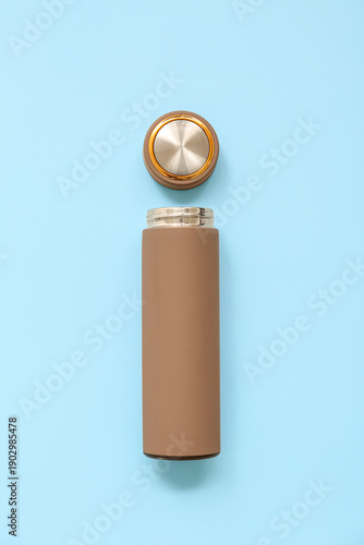 Modern brown thermos on blu...