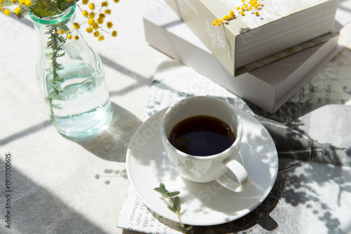窓辺に置いたコーヒーとミモザの花