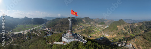 Panoramic daylight view of Lung Cu Flag Tower overlooking winding roads and rural highland villages.