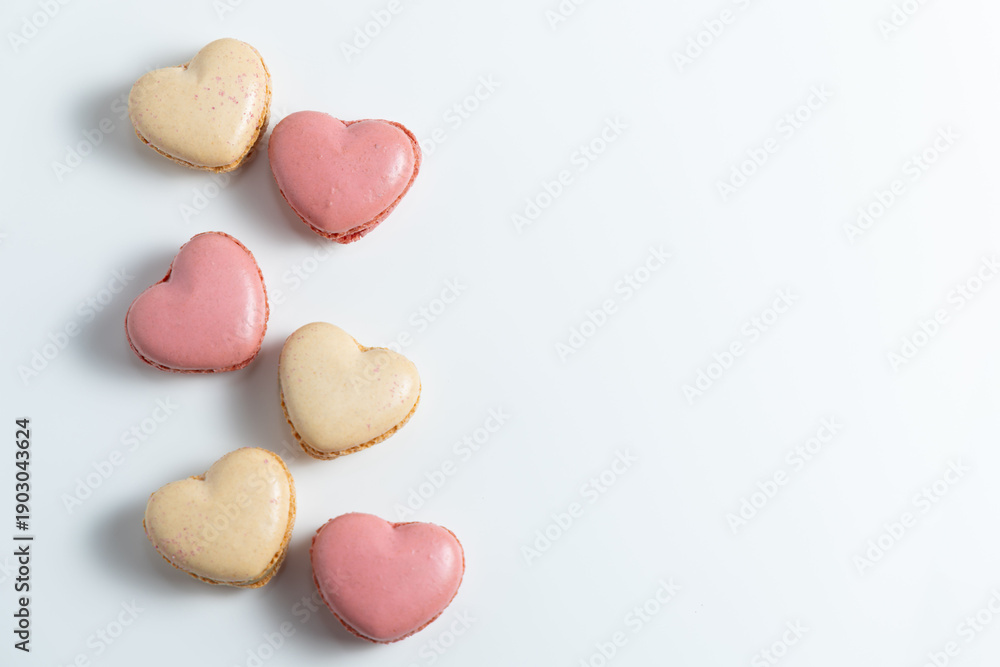 Obraz premium Heart Shaped Macarons Arranged on a White Background for Dessert Display or Decoration