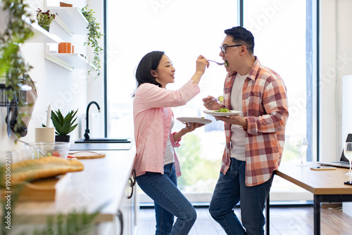 A loving couple enjoys a healthy meal together in their bright, modern kitchen