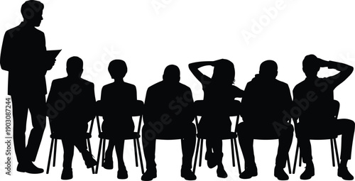 A silhouetted instructor stands before a seated group of individuals in a classroom or presentation setting