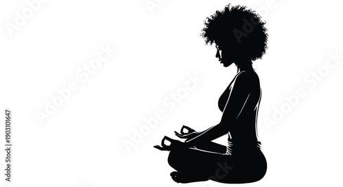 Silhouette of an african american woman with an afro meditating peacefully in the lotus pose