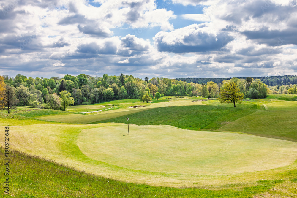Fototapeta premium Golf green on a golf course with a beautiful view on a sunny spring day