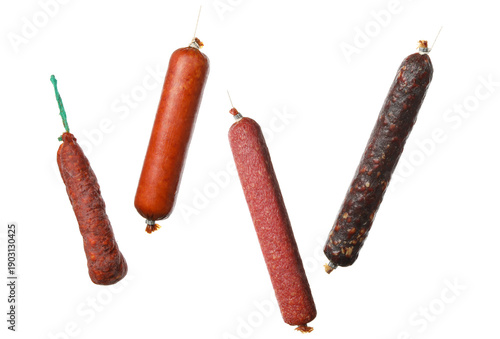 assortment of four different types of sausages, including chorizo and salami, presented on a plain transparent background, isolated food photography.