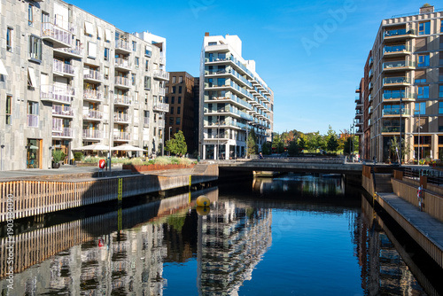 Residential urban modern architecture along a canal waterfront in Oslo Norway captures bright reflections on water and clean contemporary lines