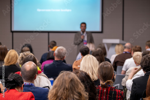 Wallpaper Mural Audience attends professional conference with speaker presenting at front of room. Diverse attendees focus on slides, network between sessions, learning skills in formal seminar setting. Torontodigital.ca