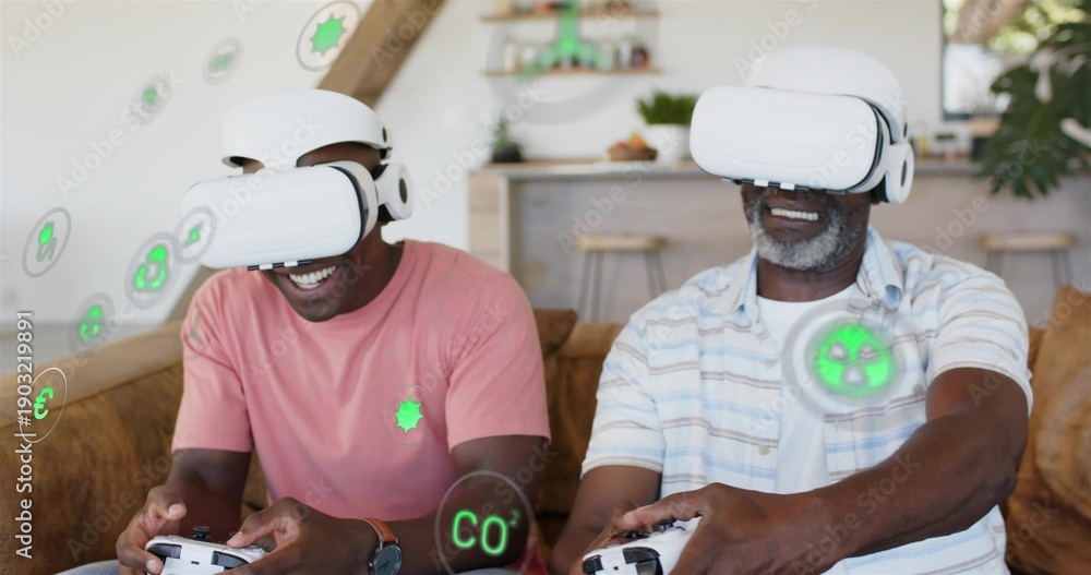 Fototapeta premium Playing duo wearing salmon and striped shirts at home, using white VR gear showing AR icons