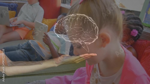 Two girls leaning in classroom while faint hand and brain graphic fading above, showing learning