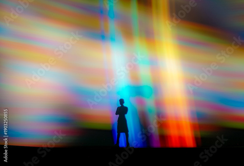 Foto Silhouette person standing in vibrant abstract light beams