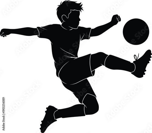 Silhouette of a boy playing soccer kicking a ball