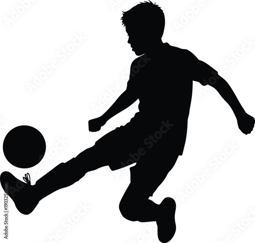 Silhouette of a boy kicking a soccer ball in motion