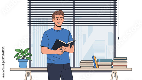 Young man standing in a bright room with a large window and blinds while reading a book next to a desk piled with more books for study.