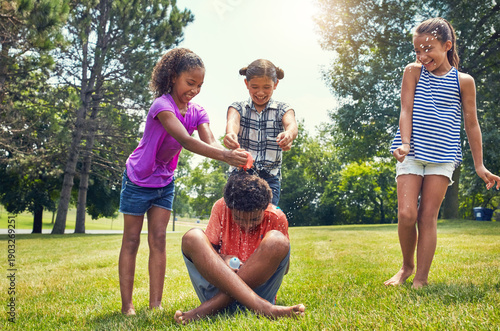 Billede på lærred Children, friends and water balloons at park with splash, playful and prank with boy summer vacation