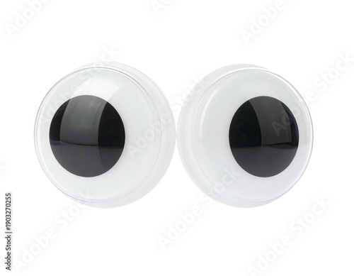 Pair of large, glossy plastic cartoon eyes with black pupils on a transparent background