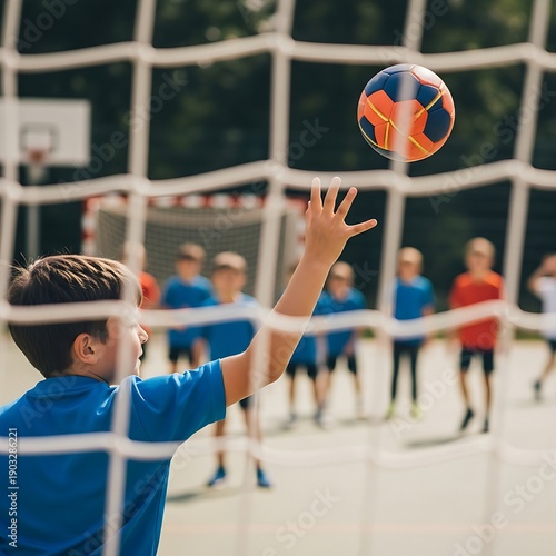 Handball: A handball being thrown toward a goal with high velocity. Group of children playing in the background, slightly blurred, candid action scene. Natural daylight, outdoor court setting, medium 