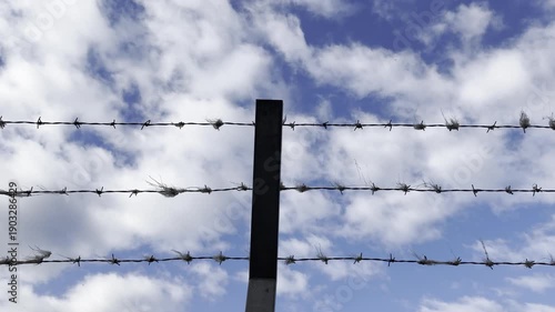 Barbed wire fence against a sky background
