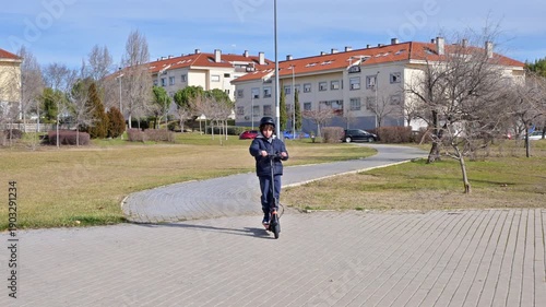 Young boy riding electric scooter in a city park